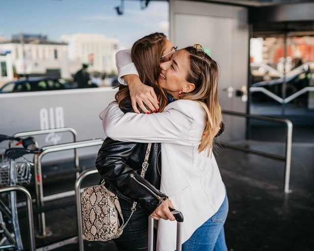 friends hugging at airport