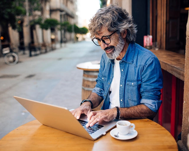 man on computer at cafe